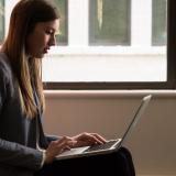 person sitting typing on a laptop